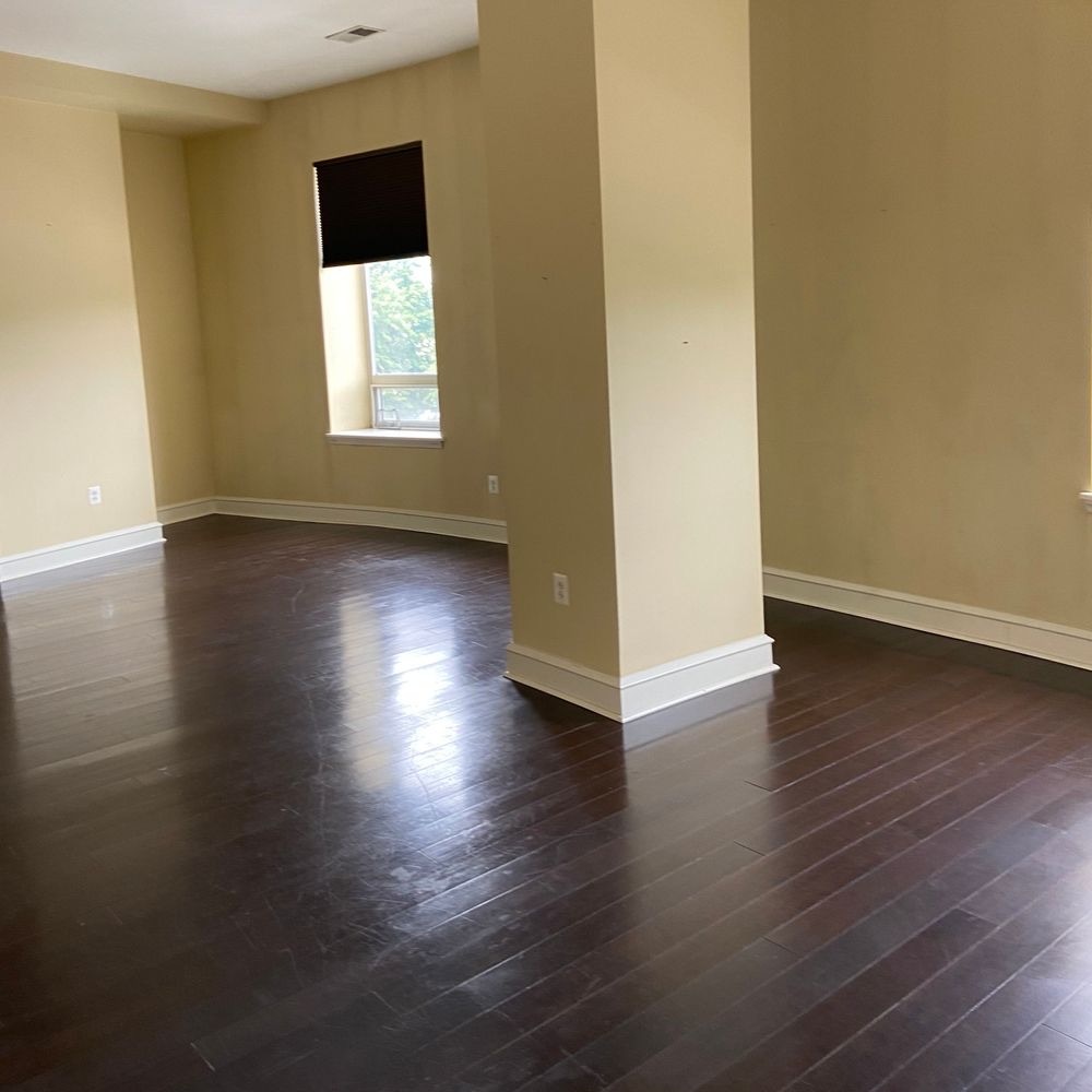 Spotless living room with gleaming hardwood floors cleaned by T C Cleaning Services LLC